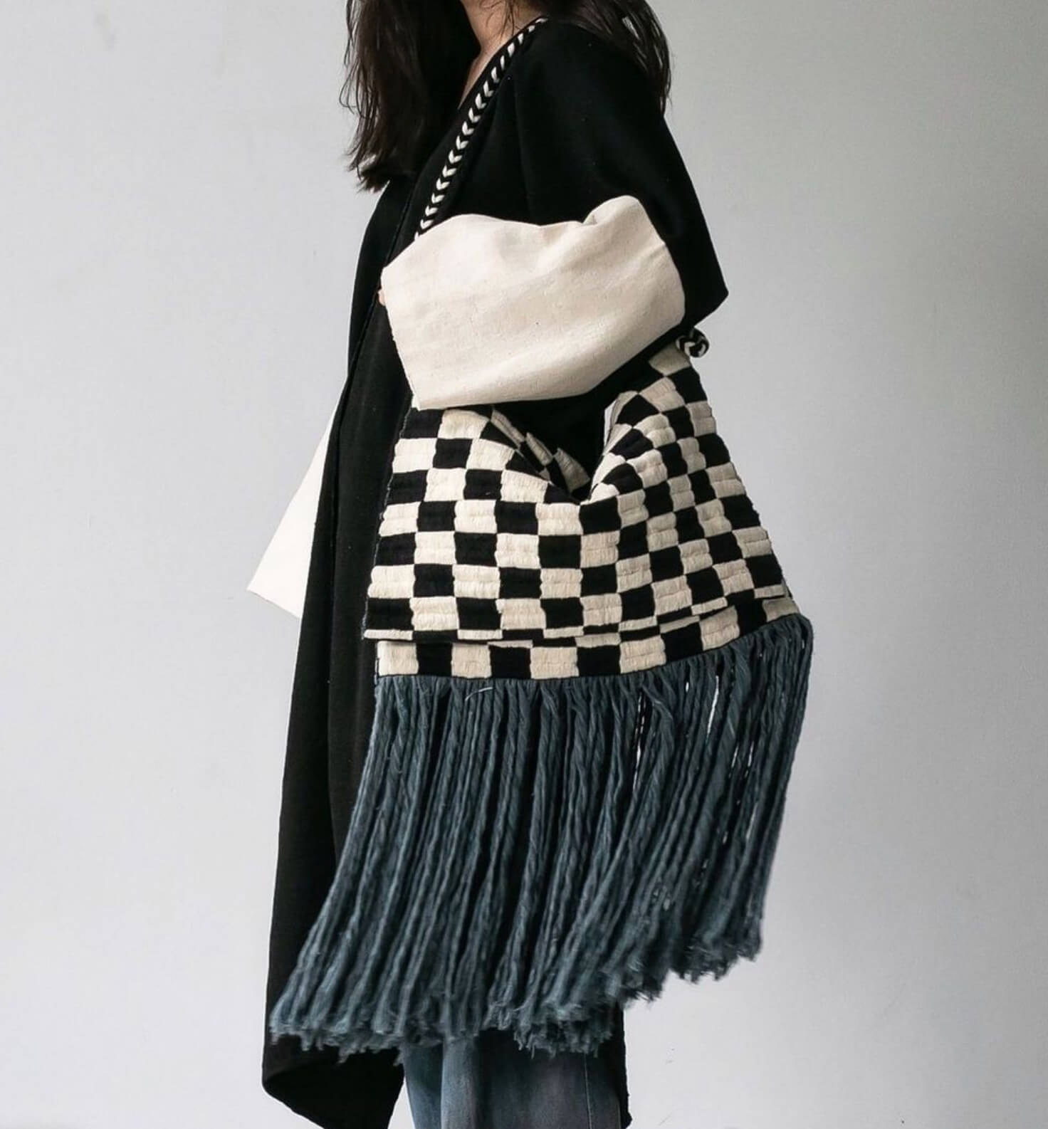 Get frisky in style. Adorned with long playful fringe, this checkered Karen shoulder bag is a wardrobe staple that will easily elevate your mood and style anytime of day